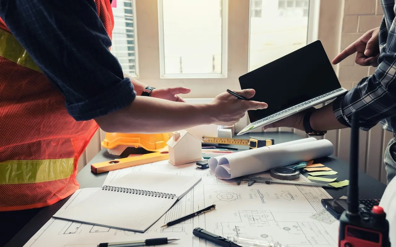 An architect reviewing residential remodeling floor plans at a desk