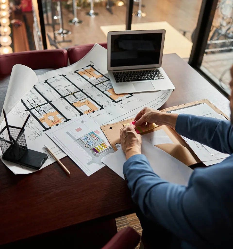 A contractor pointing at project plans on a tablet at a job site