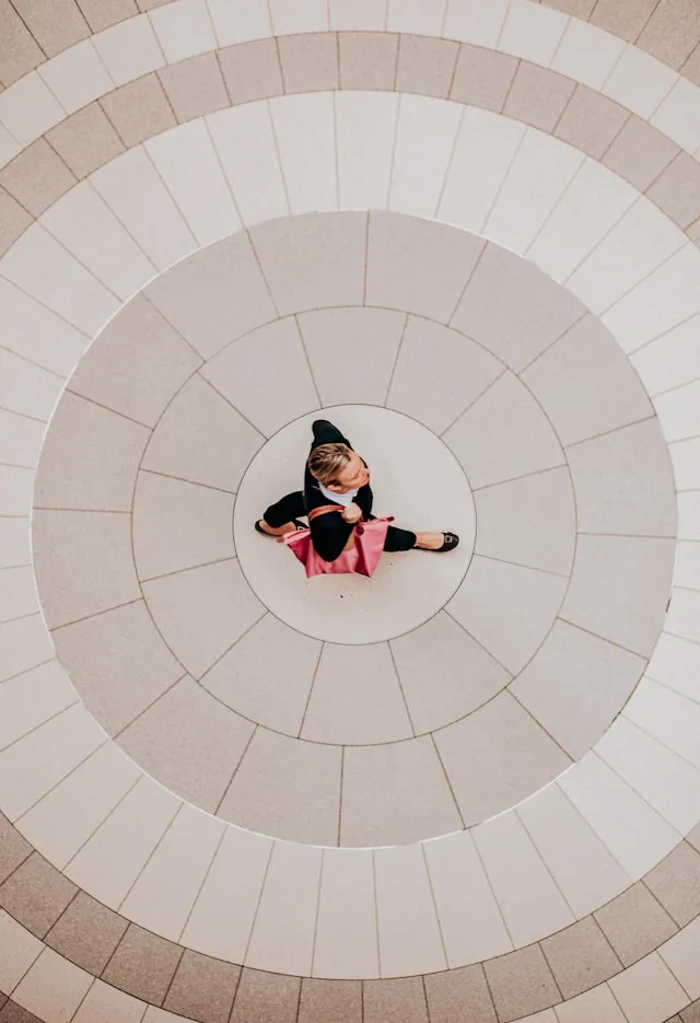 Overhead view of a consultant walking across a circular tiled floor